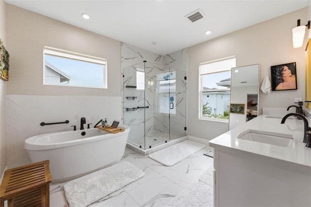 Primary bathroom with freestanding tub and frameless glass shower