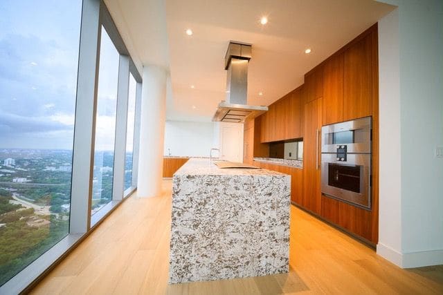 Kitchen with stone island and floor-to-ceiling glass